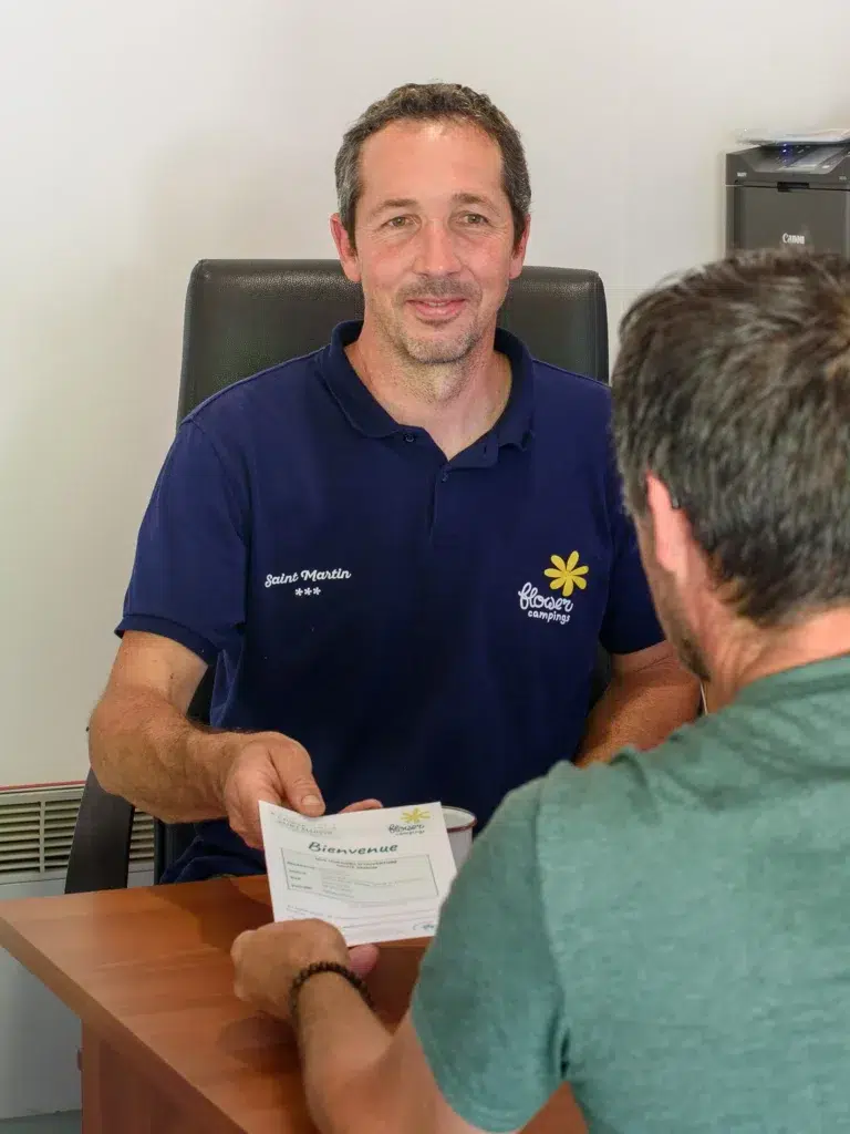 Accueil chaleureux des clients par un membre de l’équipe du Flower Camping Saint Martin, proche de Revel dans le Tarn. Idéal pour des vacances en famille ou entre amis dans un cadre convivial et naturel.