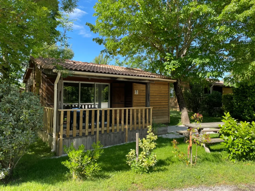 Chalet premium au camping familial Saint-Martin proche de Revel, entouré de verdure et doté d'une terrasse en bois pour des vacances en pleine nature.
