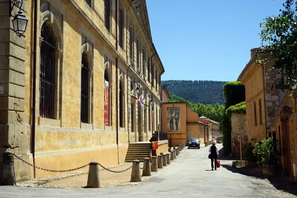Rue historique de Sorèze en Occitanie, mettant en valeur le patrimoine architectural et les bâtiments en pierre. Idéal pour une balade culturelle.