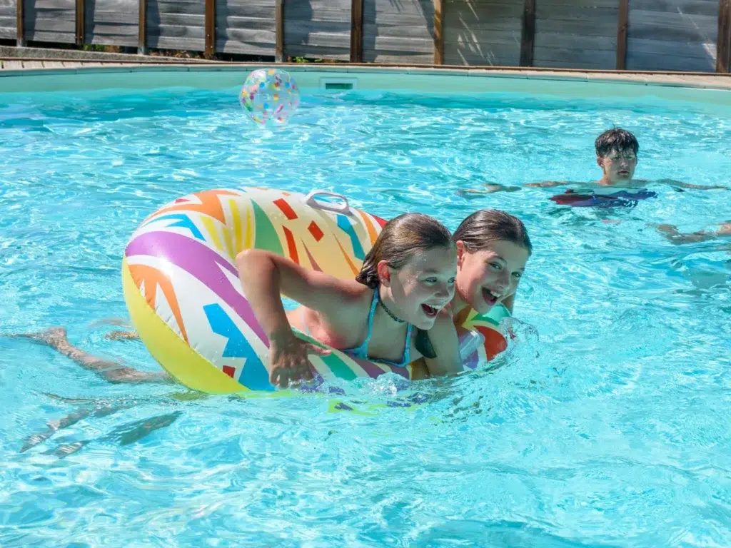 Enfants s'amusant dans la piscine du camping Saint-Martin, près du lac Saint-Ferréol dans le Tarn, pour des vacances en famille pleines de joie et de détente.