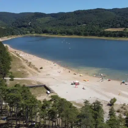 Vue aérienne du lac Saint-Ferréol avec sa plage de sable, ses activités nautiques et ses espaces verts. Idéal pour des vacances en famille, des balades et des sports nautiques dans le Tarn. Découvrez le lac Saint-Ferréol et sa plage de sable, un lieu parfait pour des activités nautiques et des vacances en famille dans le Tarn.