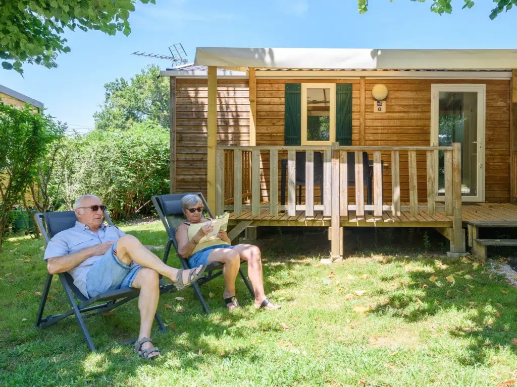 Mobil-home en bois au camping Saint-Martin, entouré de verdure et proche du lac Saint-Ferréol, idéal pour des vacances calmes en pleine nature.