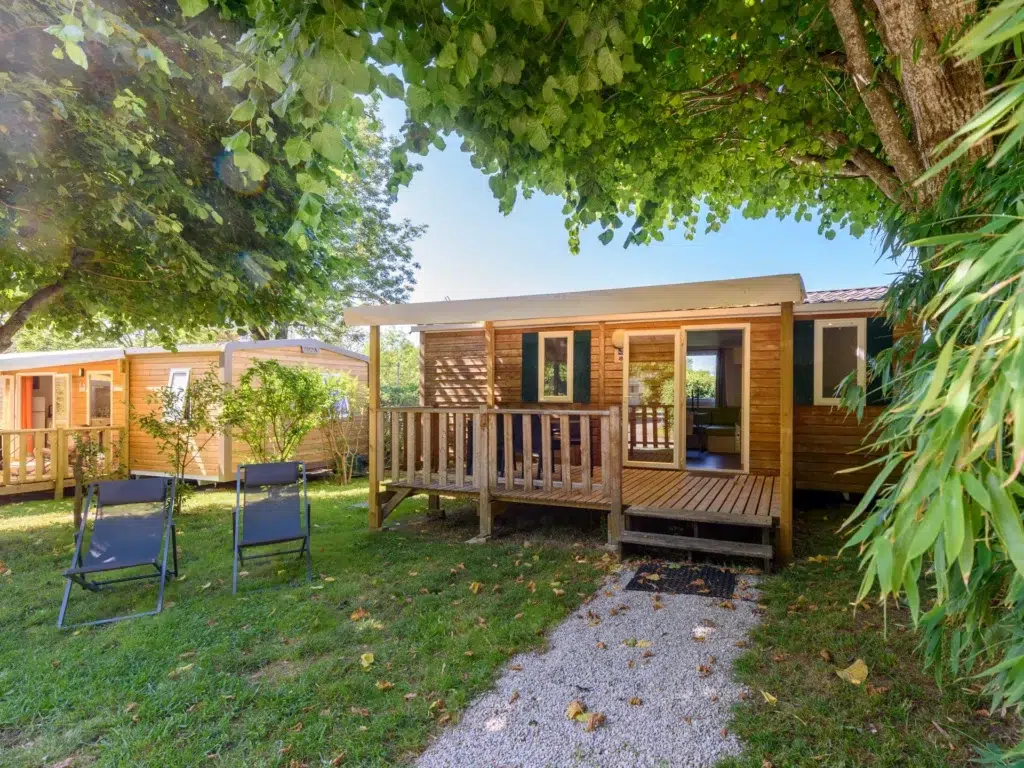 Mobil-home en bois avec terrasse dans un cadre calme et verdoyant au camping Saint Martin, proche de Carcassonne. Idéal pour des vacances reposantes en pleine nature avec tout le confort moderne.
