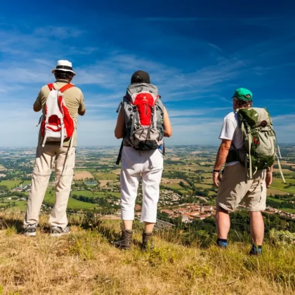 Accueil 24 Trois randonneurs admirant le panorama en Montagne Noire depuis l'oppidum de Berniquaut, surplombant Sorèze dans le Tarn. Profitez de randonnées inoubliables en Montagne Noire, comme