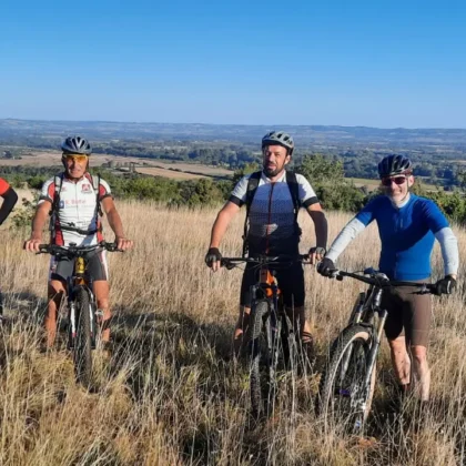 A faire 5 Groupe de cyclistes en tenue de VTT posant en Montagne Noire au départ d'une sortie depuis le camping Saint-Martin, avec paysages naturels en arrière-plan. Explorez la Montagne Noire en VTT au départ du camping Saint-Martin, pour des aventures sportives en pleine nature.