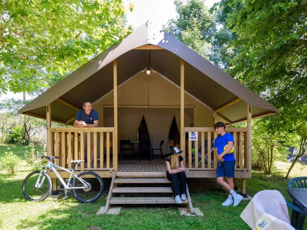 Tente lodge en pleine nature pour une expérience de glamping au camping Saint Martin dans le sud du Tarn, avec terrasse en bois. Idéal pour des vacances insolites et confortables en pleine nature.