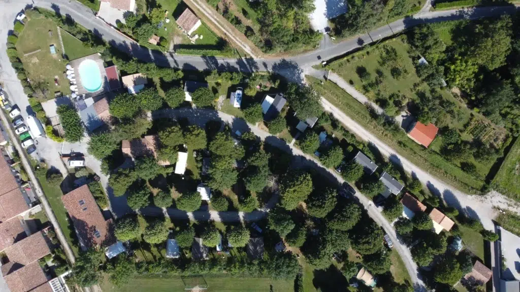 Vue aérienne du Camping Saint Martin à Sorèze avec sa piscine, ses hébergements et ses emplacements ombragés au cœur du Tarn.